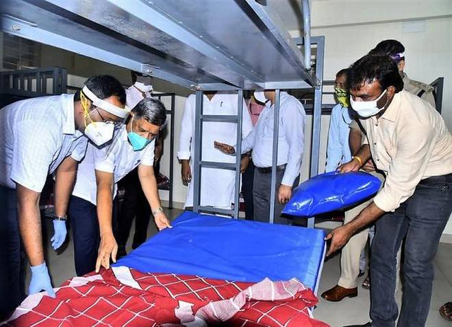 Jagadish Shettar, District in-charge Minister checking the beds and pillow quality during the inauguration of 800-bed Covid Care-Centre set up
